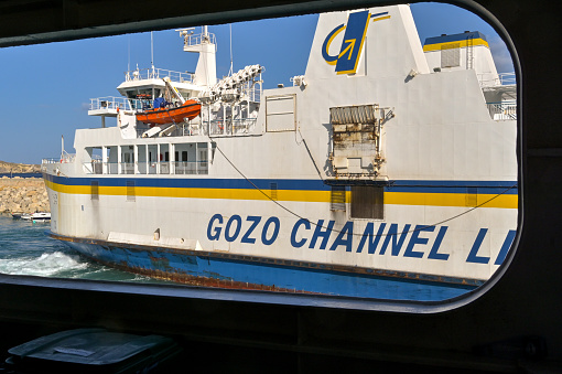 Gozo, Malta - 5 August 2023: Ferry in Mgarr harbour on the island of Gozo with view frame by the deck of another ferry.The ferry is operated by Gozo Channel Line.