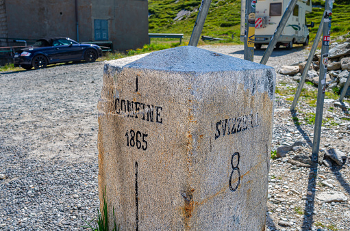 Splugenpass, Switzerland - July 9, 2023: The boundary stone between Switzerland and Italy at Splugenpass - Passo Spluga