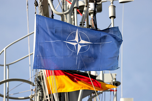 Cuxhaven, Germany - October 25, 2021: flag of the North Atlantic Treaty Organization (NATO) flying in the wind on the mast of a warship