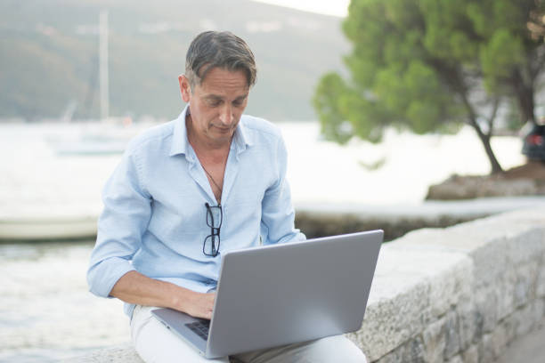 istock Mature adult man working on the beach 1621415844