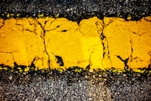 Yellow Line Close-up painted on the asphalt.
