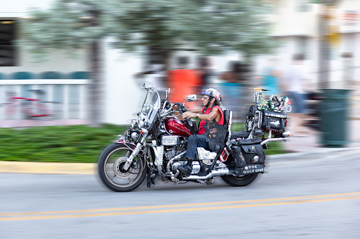 Miami, USA - August 23, 2014: elderly man on a Harley cruises  in the art deco district in South Beach, Miami, USA.