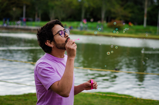 gay man playing with soap bubbles