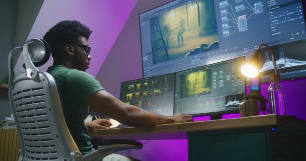 istock African American video editor makes color grading on PC 1621437861
