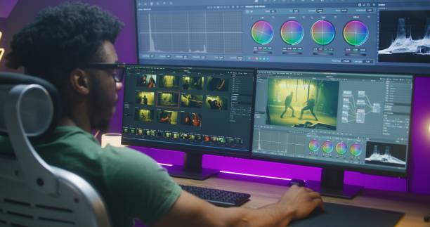 African American colorist edits action movie, works at home African American colorist edits action movie, makes color correction, works at home. Program interface with RGB tools and wheels on computer and big digital screen. Concept of film post production. photo editing screen stock pictures, royalty-free photos & images