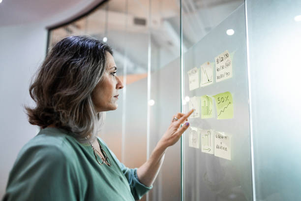 istock Mature businesswoman planning looking for post it at office 1621460678