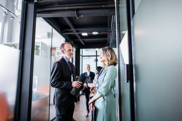 istock Business persons talking at corridor office 1621461735