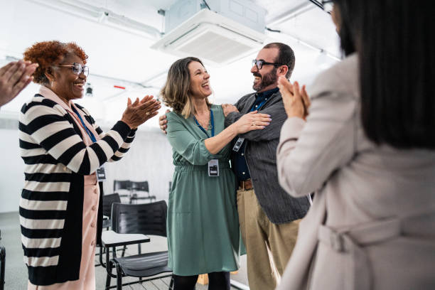 istock Happy coworkers embracing during a meeting at office 1621469792