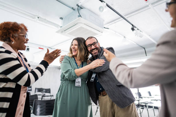 istock Happy coworkers embracing during a meeting at office 1621469794