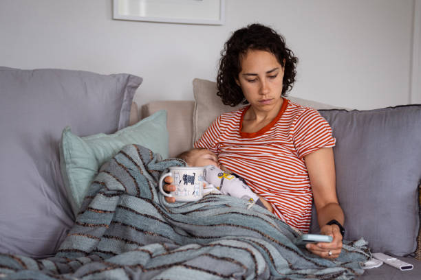 istock Mother looks at her phone while nursing son 1621469802