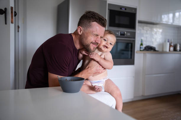 istock Father laughs as he eats lunch with baby son 1621469819