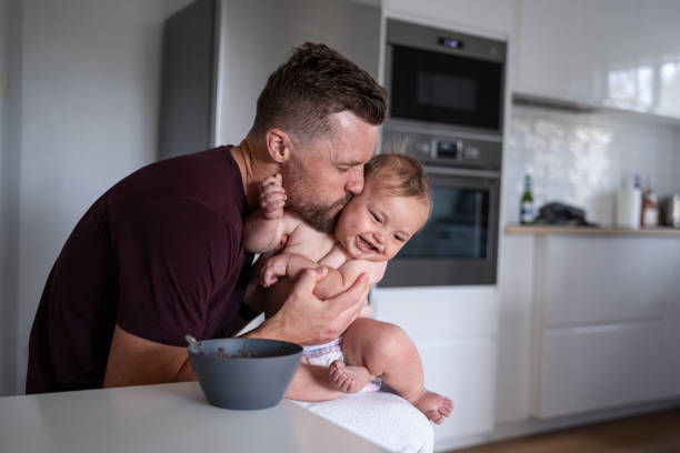 istock Father kisses son on the cheek while feeding him lunch 1621469820