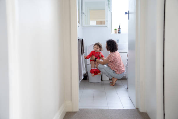 istock Mother sits next to daughter while potty training her 1621469861