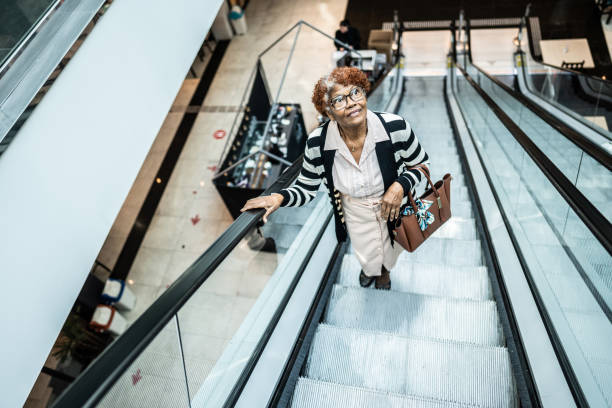 istock Senior woman moving up on a escalator 1621477575