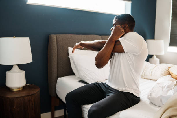 istock Young man stretches arms after waking up 1621478125