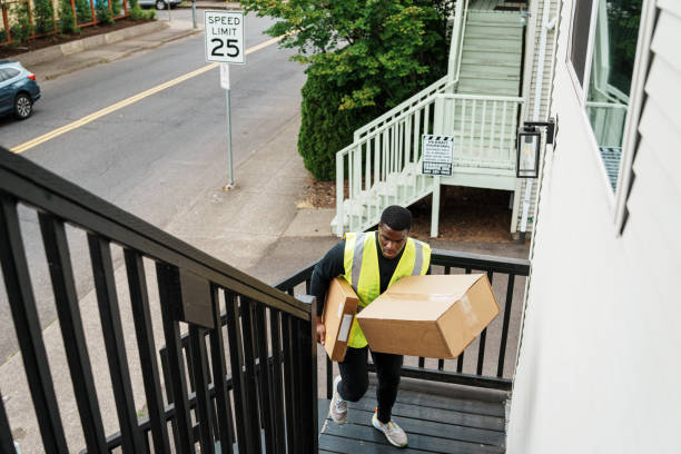 istock Delivery man walks up stairs, dropping off a package 1621478144