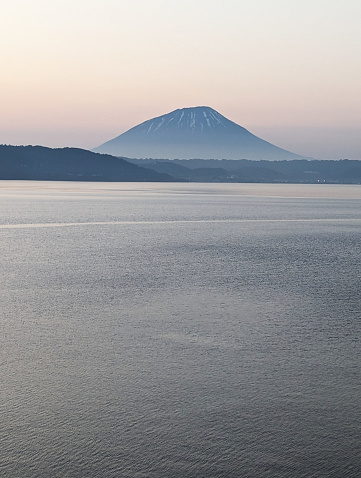 View looking northwest across Lake Toya, a caldera lake, to Mount Yotei, a stratovolcano. Twilight in Toyako-cho, a hot springs resort in Abuta District.