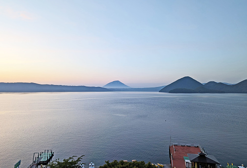 Toyako-cho, Japan - June 8, 2023: View from the south lakeshore of Toyako across to Mount Yotei, a stratovolcano. The Nakajima Island group stands to the right.