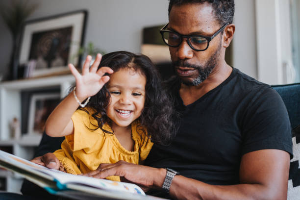 istock Loving father reads a book with his mixed race daughter 1621498024