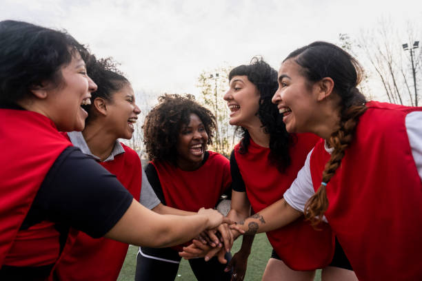 istock Amateur female football team having fun while stacking hands 1621531562