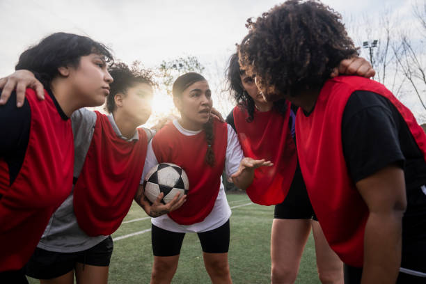 istock Female football team discussing while huddling before match 1621532120