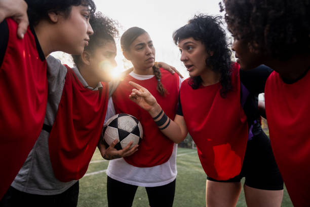 istock Female football team discussing while huddling before match 1621532661