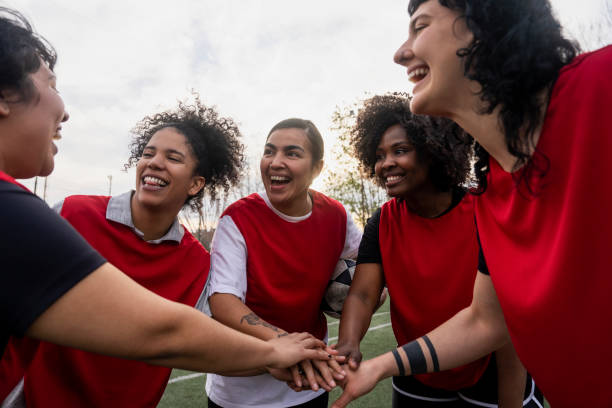 istock Amateur female football team stacking hands before match 1621533767