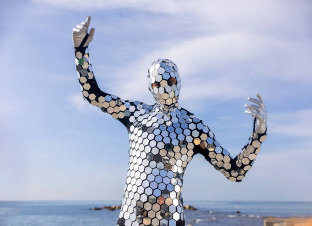 Mr discoball wearing full mirror suit dancing by the sea