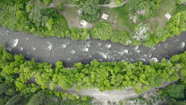 Aerial overhead flooded Provo River with recreational sites, firepits, bike path
