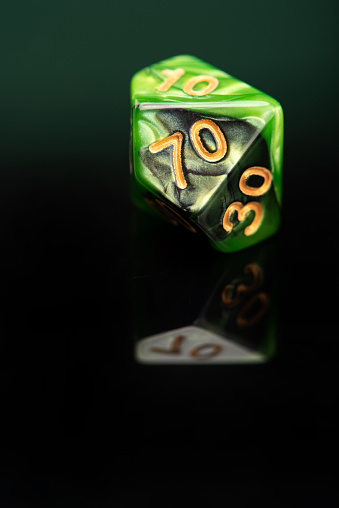RPG dice, beautiful RPG dice placed on reflective surface and dark background, selective focus.