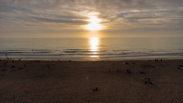 sylwetka surferów na zatłoczonej plaży o zachodzie słońca, ericeira - ericeira zdjęcia i obrazy z banku zdjęć