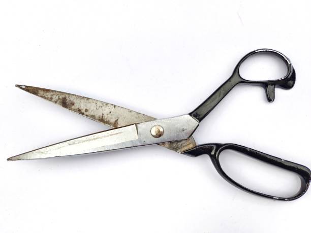 istock Selective focus of a worn out scissor with open blade and black handle isolated on white background 1621778571