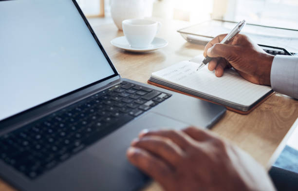 istock Hands, laptop and man writing notes for business schedule, office administration and reminder. Closeup worker, computer planning and notebook of ideas, information and strategy planner at table 1621887013