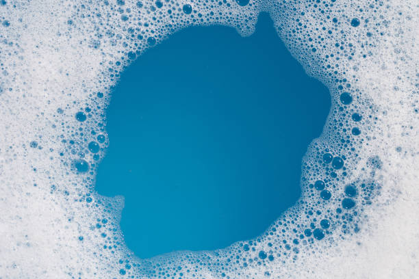 istock Detergent foam bubble on water. Blue background, Soap sud 1621905042