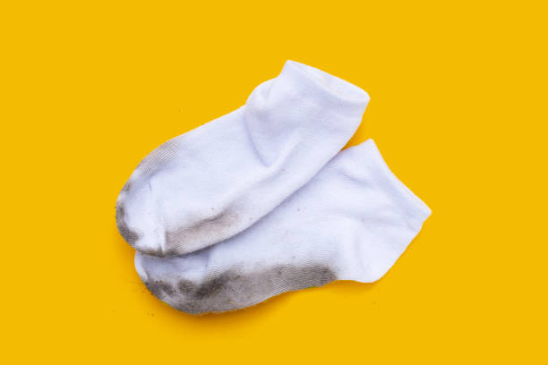 istock Dirty white socks on yellow background. 1621907187
