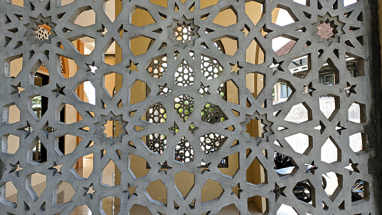 Krawangan or screen of the mosque wall complex with star motifs. Roster wall as air and light circulation. Arabic and Turkish style wall facades.