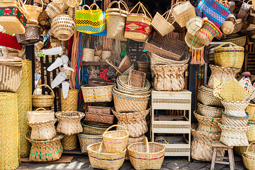 A pile of handmade traditional woven baskets made from straw, natural fiber, for sale at the outdoor market in Cuenca, Ecuador