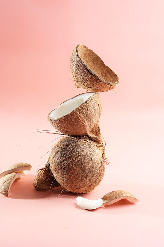Stacked Coconut Meat and Coconut Shell on Pink Background, Concept Natural Ripe COconut. Copy Space for Text