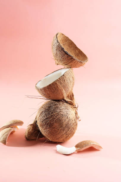 Stacked Coconut Meat and Coconut Shell on Pink Background stock photo