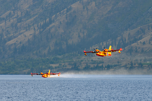 PEACHLAND, BC - JULY 21: Aerial firefighters flying Super Scoopers from Bridger Aerospace in Montana battle Okanagan wildfires refilling with water from Okanagan Lake in Peachland, BC on July 21, 2023.