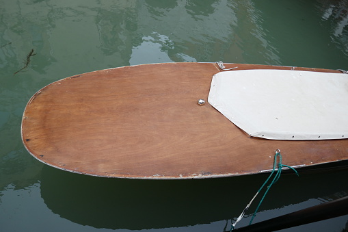 Wooden boat moored and floating on canal water