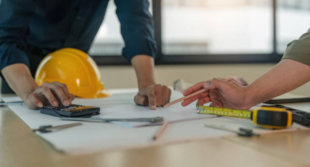 istock Closeup hand of engineer team with construction work plan discussion together blueprint on working table in construction site with safety helmet 1622054948