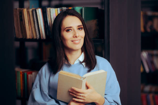 istock Happy Woman Reading a Book in a Public Library 1622055416