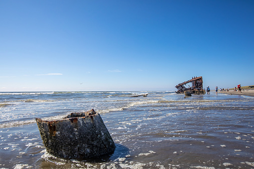 Warrenton, USA - August 8, 2023. People visit the Fort Stevens State Park beach on a hot summer day. The famous 1906 wreck of the Peter Iredale remnants attract tourists.