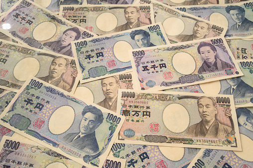 Randomly scattered Japanese 1000, 5000 and 10000 yen banknotes background.