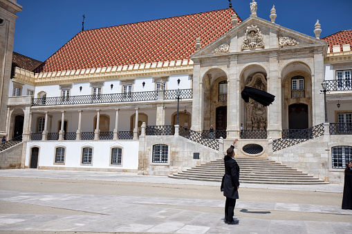 Exterior view of University of Coimbra, Coimbra, Portugal. Students wearing black robes for photo.