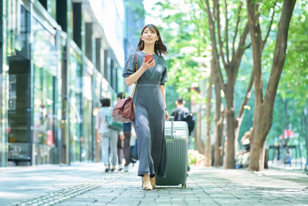 uma mulher andando na cidade com uma mala - urban scene business travel travel asia - fotografias e filmes do acervo