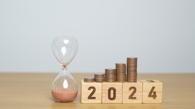 Happy New Year with sandglass and flipping 2023 change to 2024 block. Resolution, Goals, Plan, Action, Money Saving, Retirement fund, Pension, Investment and Financial concept
