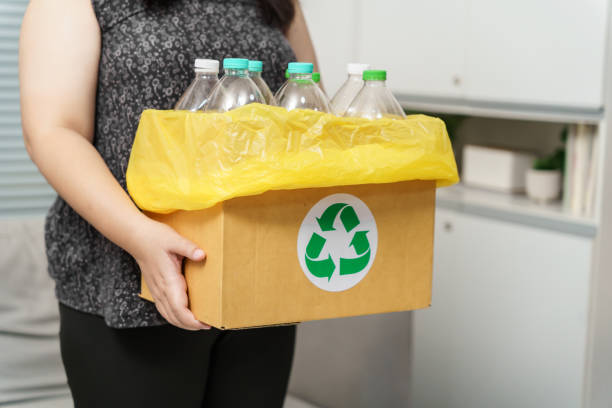 istock Home recycle eco green zero concept Woman throwing empty plastic bottle in recycling bin with yellow garbage bags at home. 1622172546