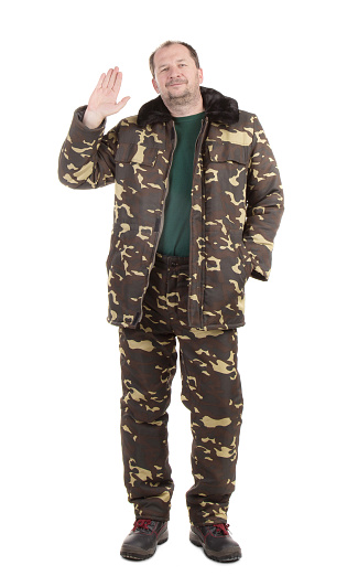 A man in warm camouflage clothes greets all by raising his hand. Isolated on a white background. Close-up.